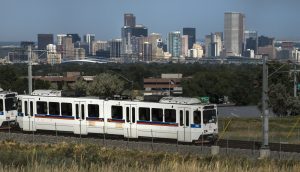 Light rail carries evening commuters home past the the downtown Denver, Colorado skyline, reducing traffic.